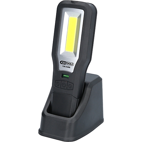 Zwarte LED-werkplaatslamp met oplaadstation. Boven een lichtveld, daaronder het KS TOOLS logo en oplaadindicator.